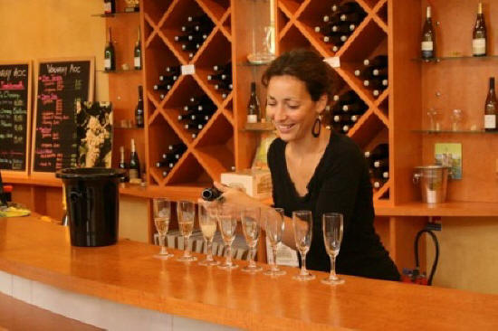 young woman pouring sparkling Vouvray wine to taste